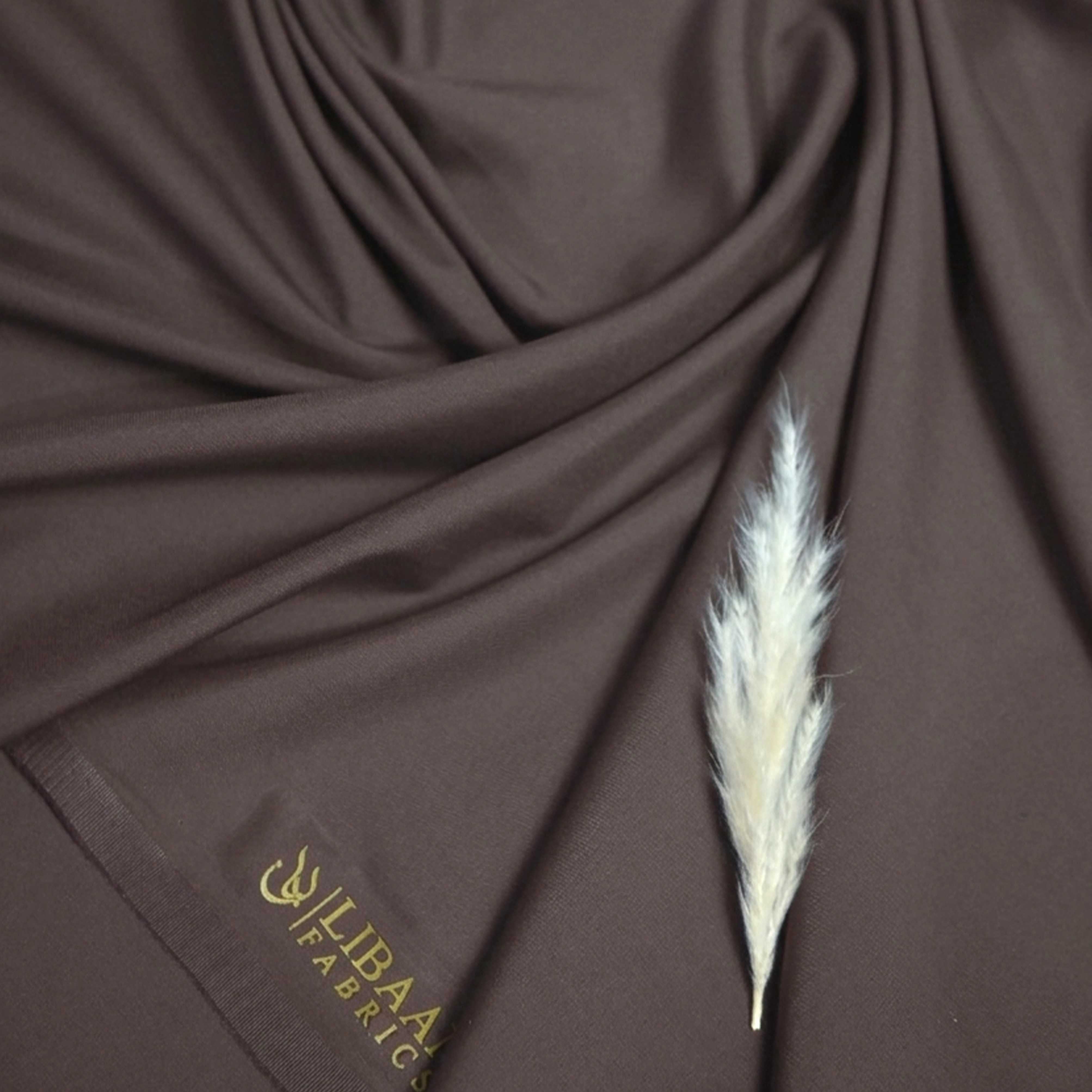 Brown fabric with a feather and 'LIBAAN FABRICS' fabric logo in the corner