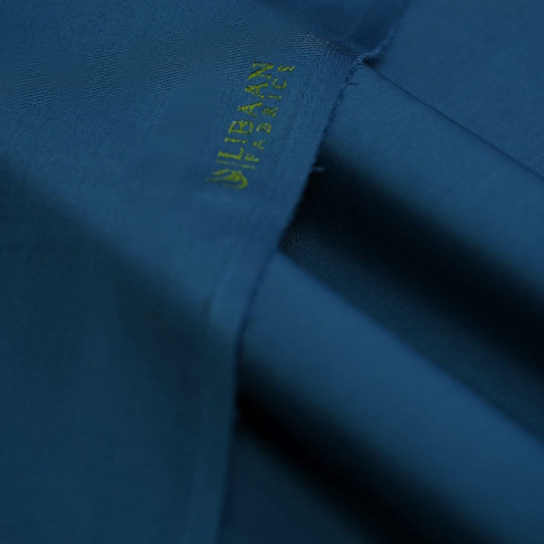 Close-up of a blue fabric with a brand logo embroidered on it.