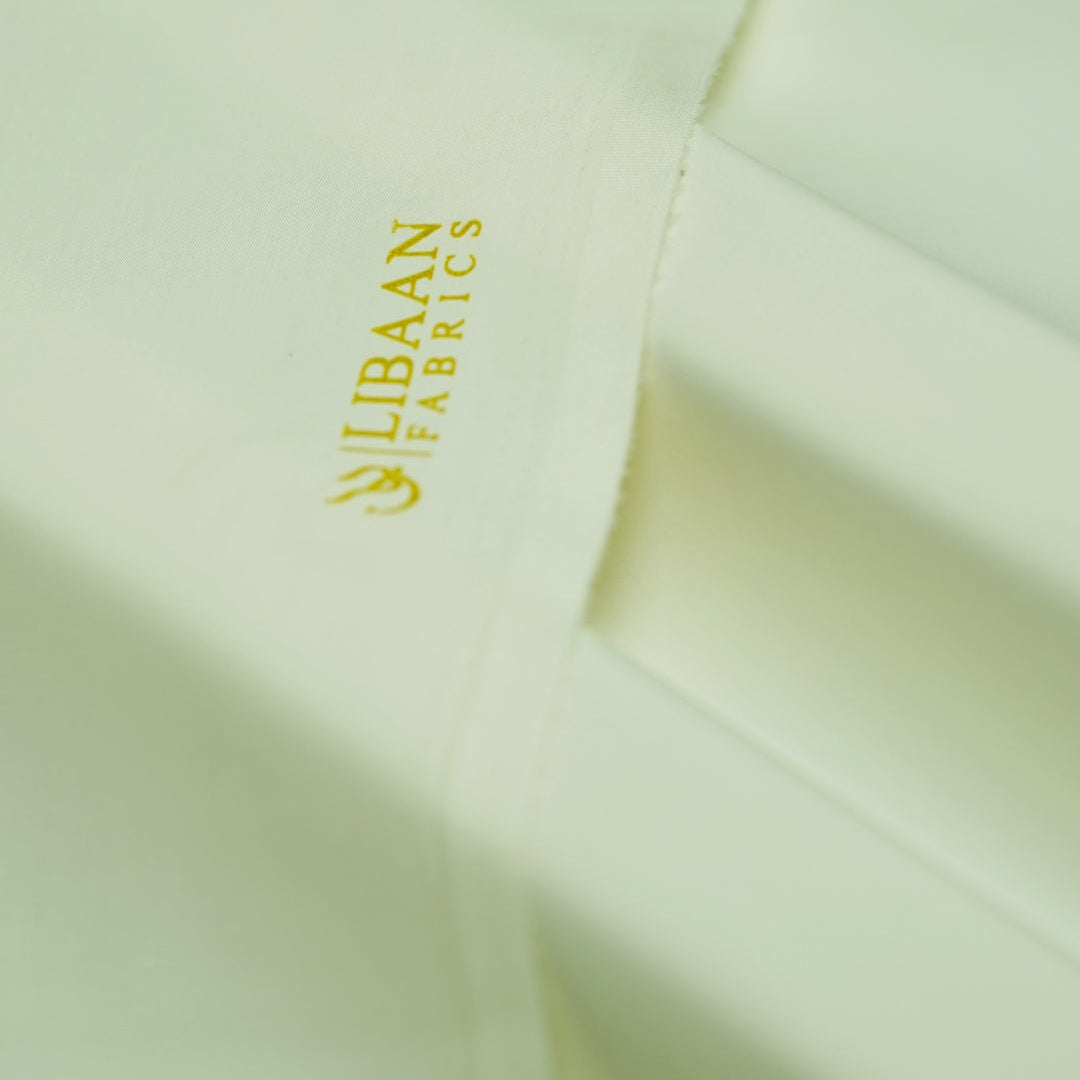 Close-up of light green fabric with 'Libaan Fabrics' logo.