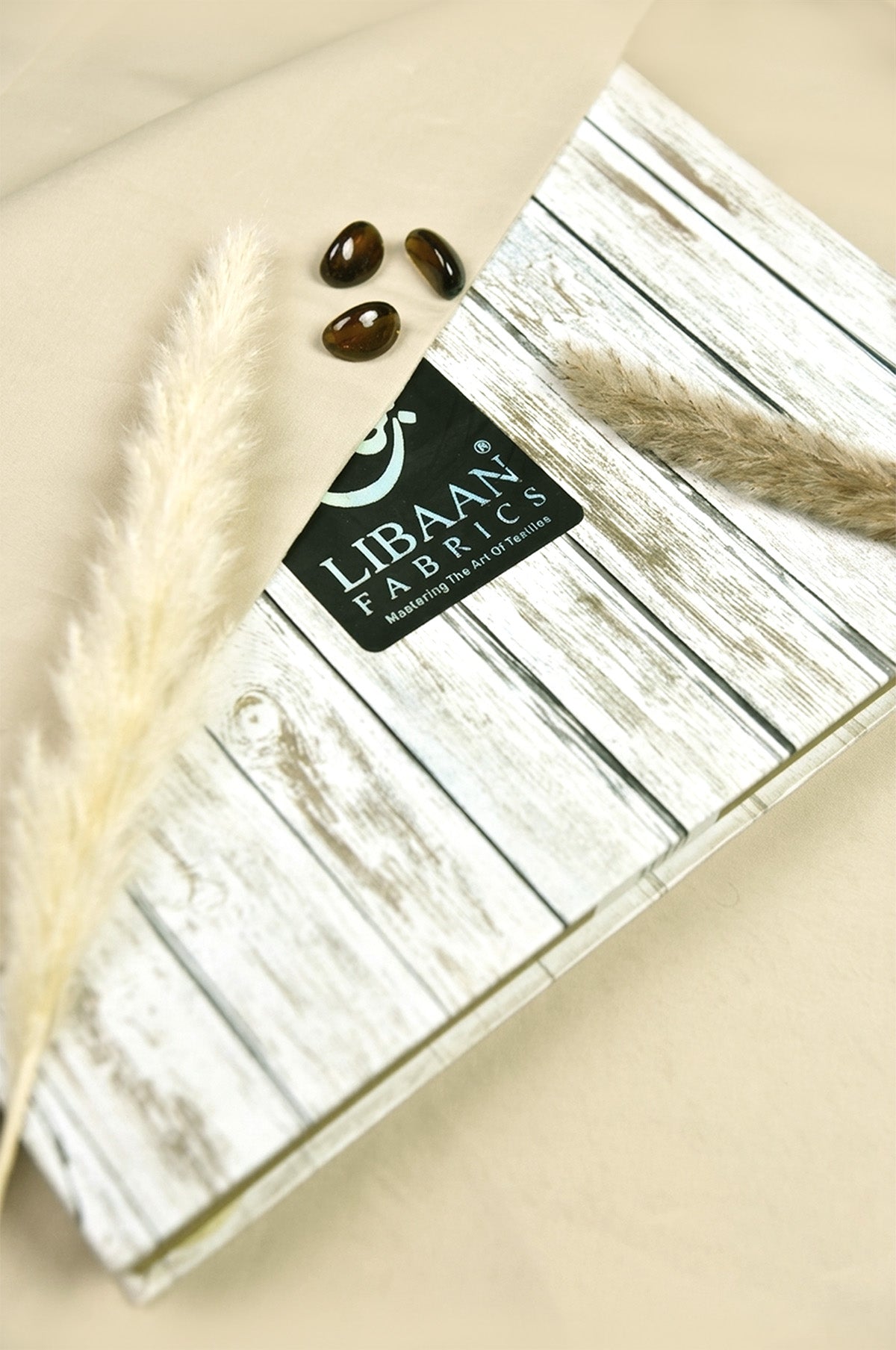 Pack of Libaan Fabrics with decorative elements on a beige background