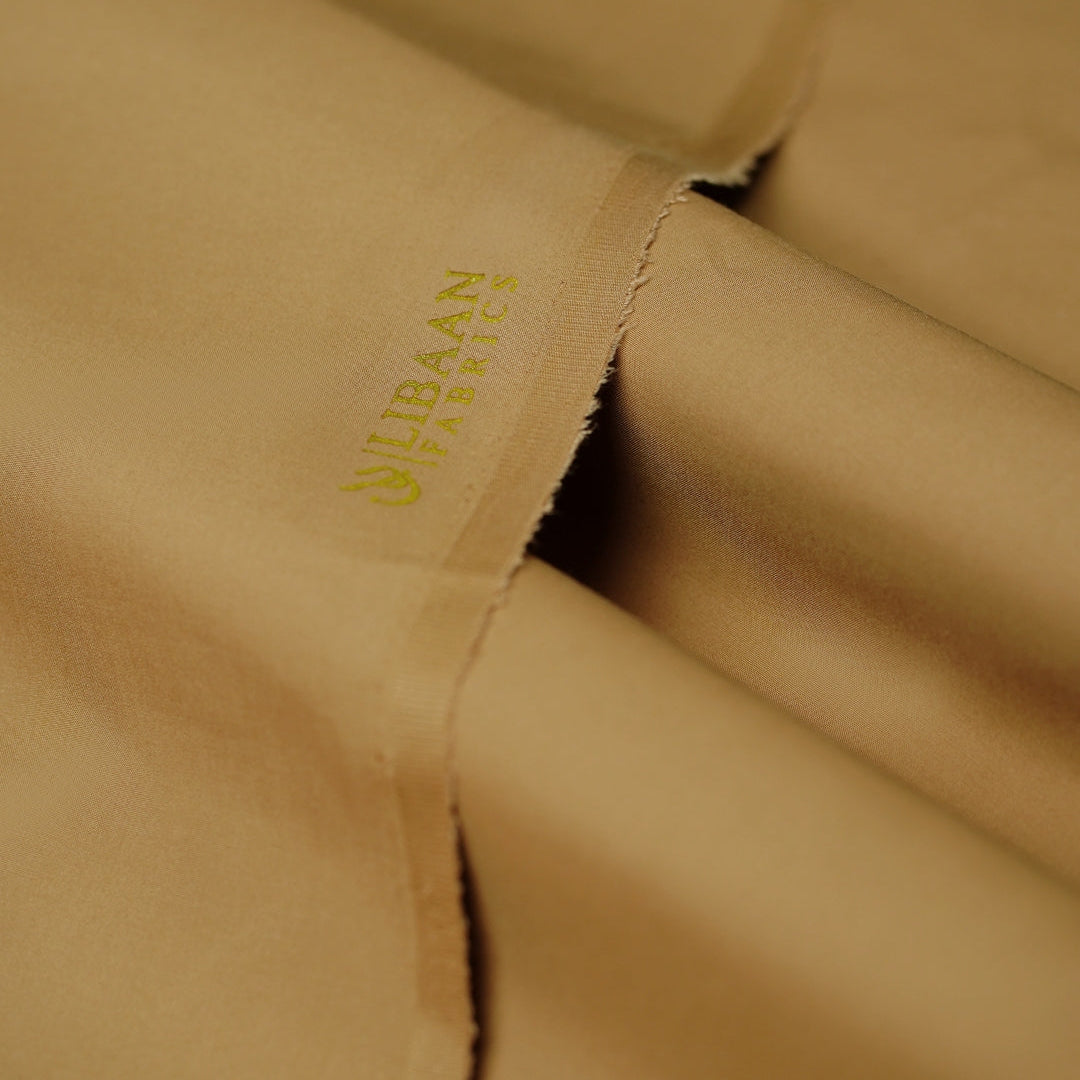 Close-up of beige fabric with a brand logo embroidered on it.