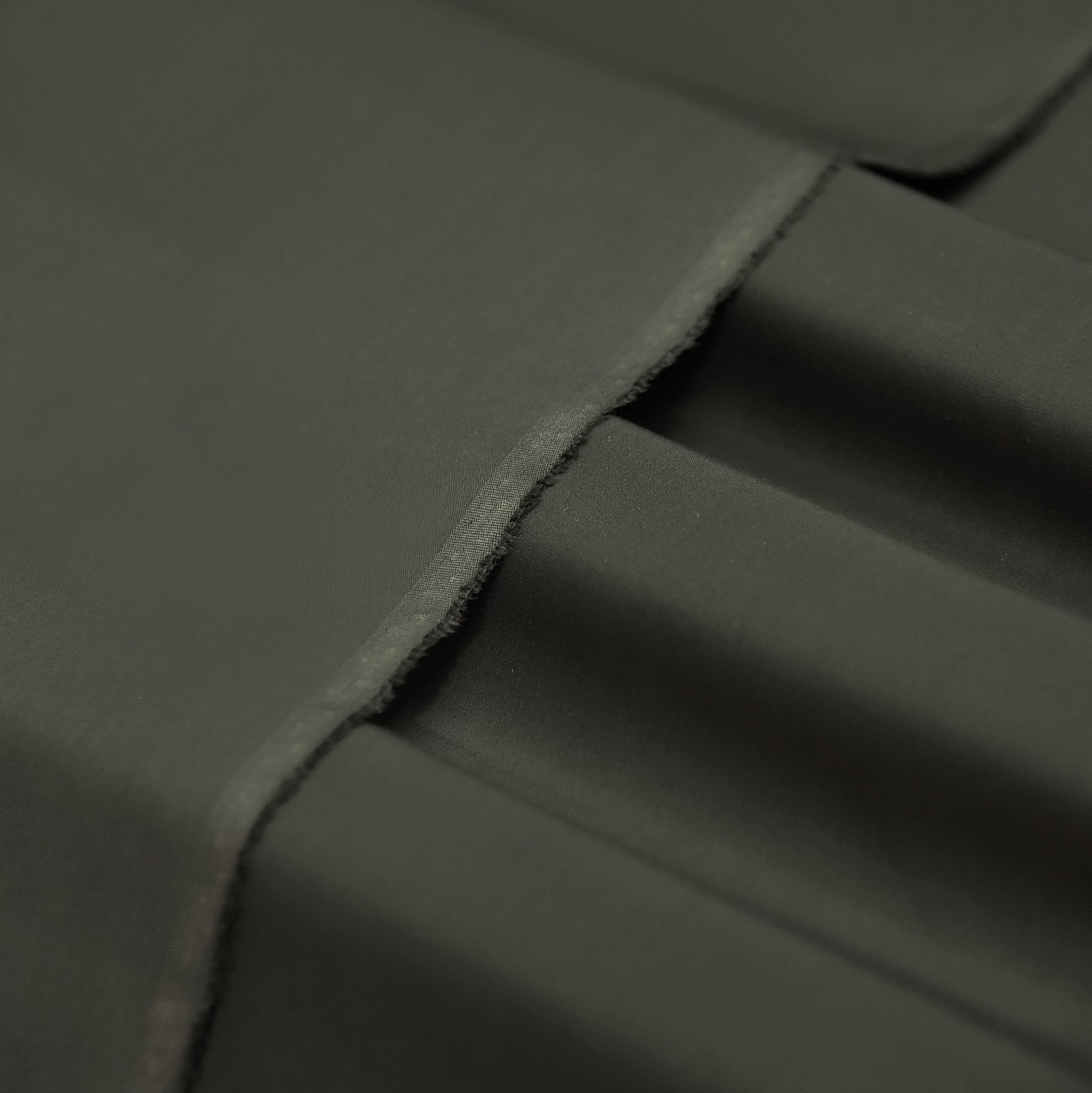 Dark gray fabric with a slight texture and visible folds.