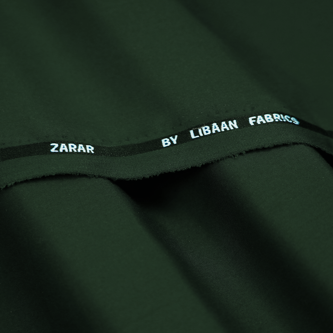Close-up of green fabric with 'Zarar by Libaan Fabrics' label.