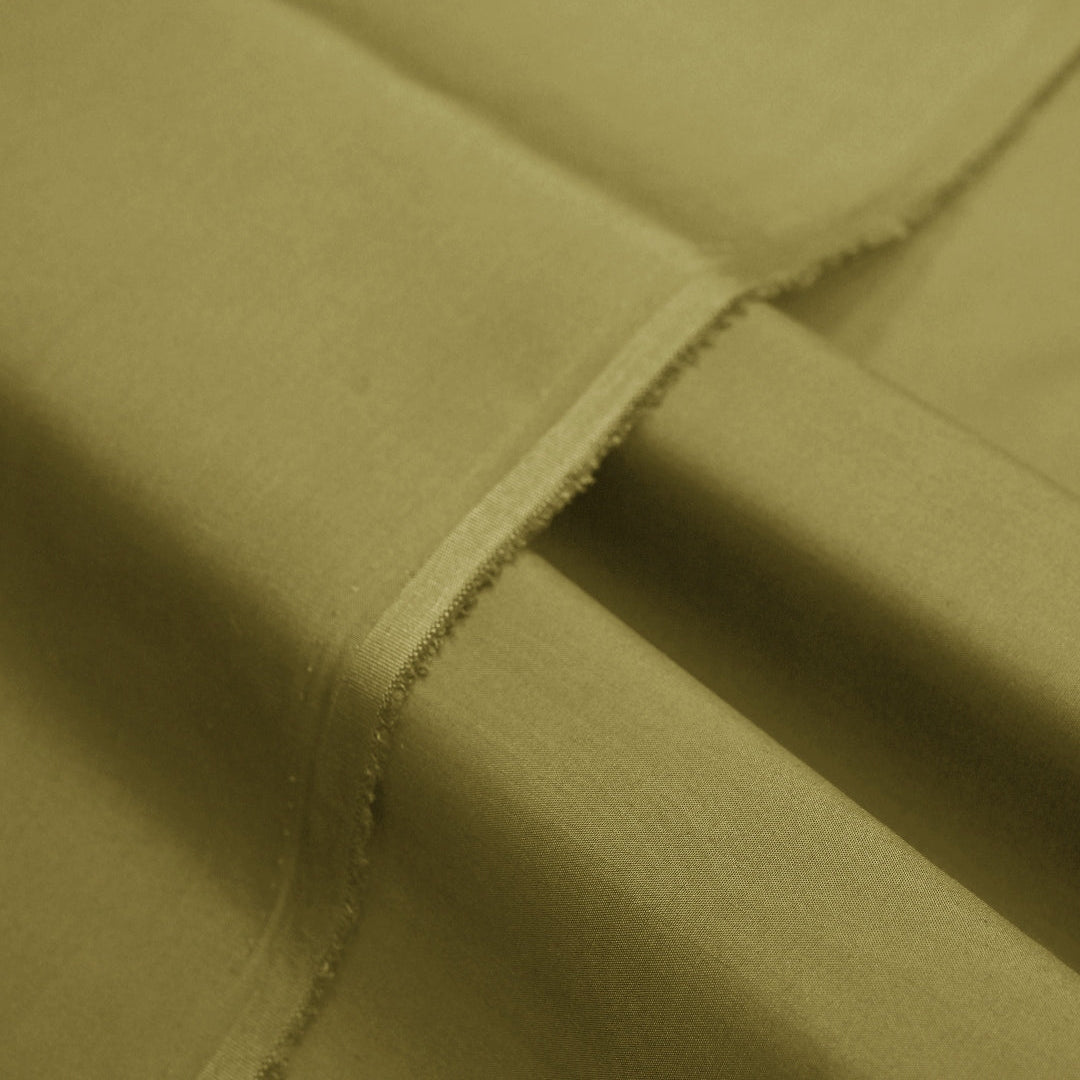 Close-up of olive green fabric with visible stitching