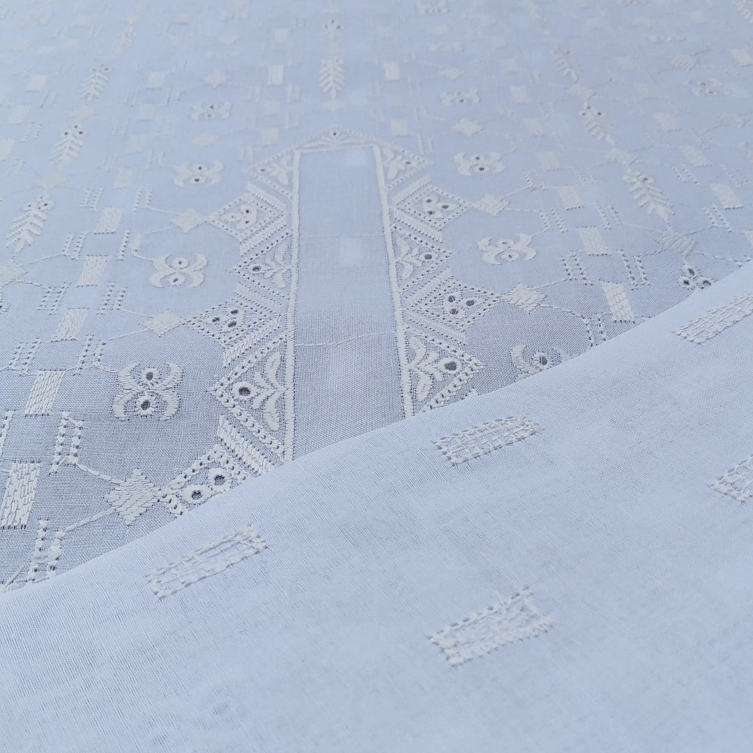 Light blue fabric with intricate white embroidery pattern