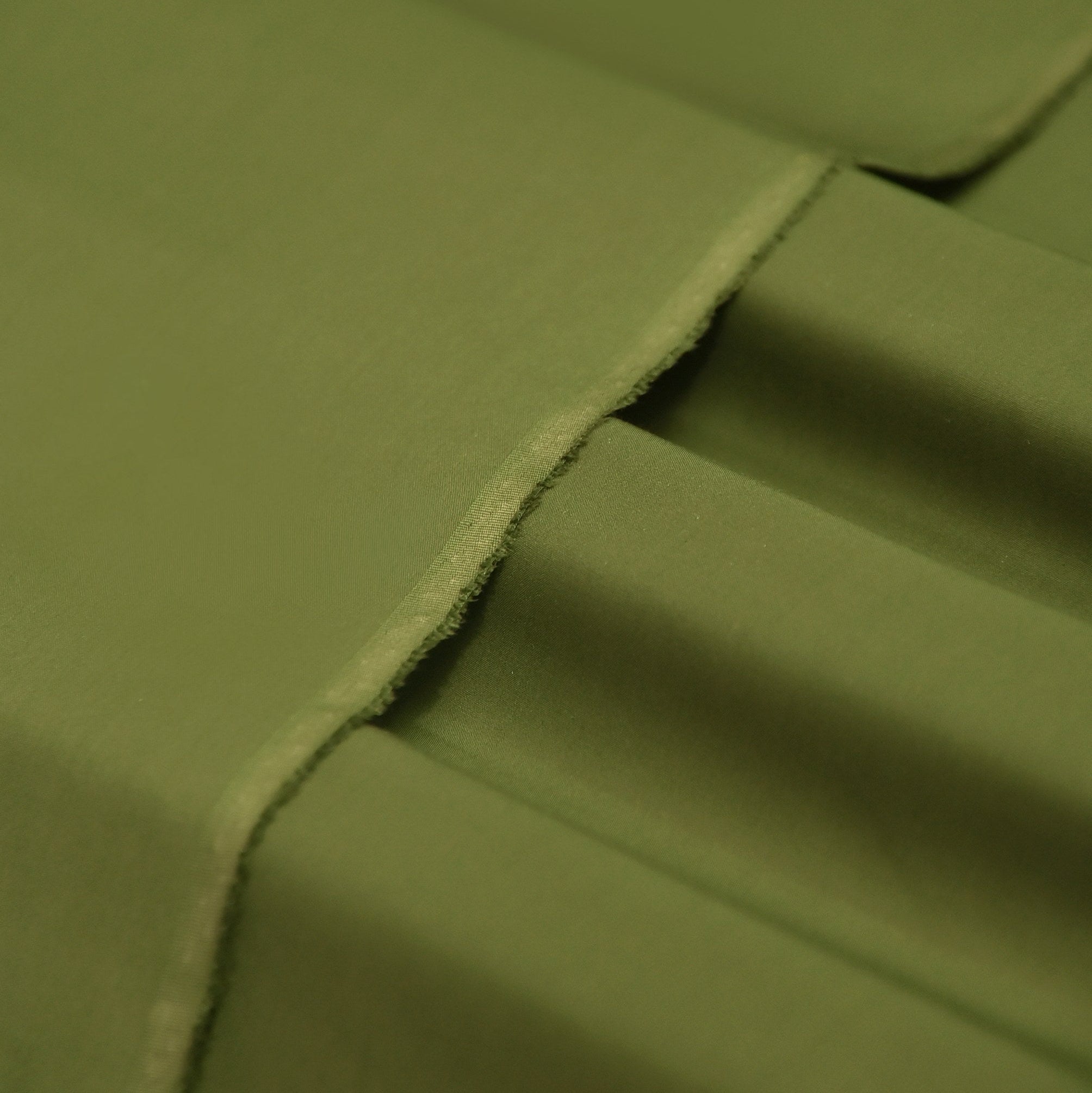 Close-up of green fabric with a visible seam