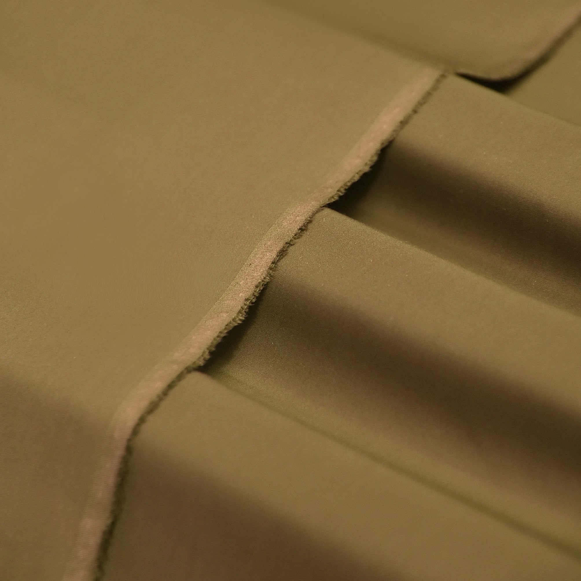 Brown fabric with buttons and dried plants on a textured surface