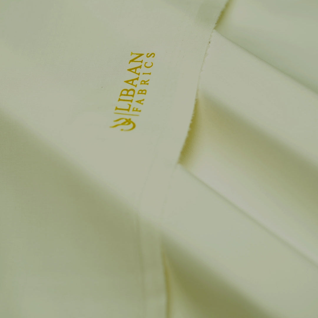Close-up of light green fabric with 'Elbaan Fabrics' logo.
